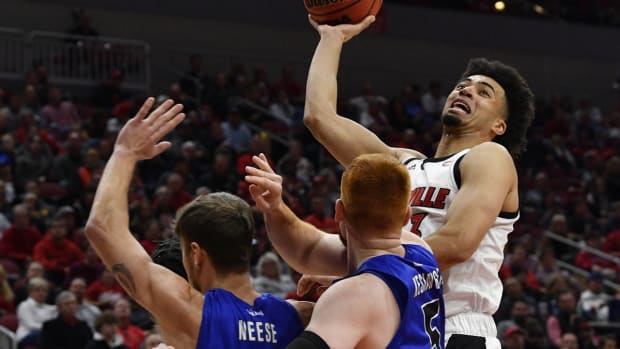 Nov 13, 2019; Louisville, KY, USA; Louisville Cardinals forward Jordan Nwora (right) shoots against Indiana State Sycamores guard Cooper Neese (4) and center Bronson Kessinger (5) during the second half at KFC Yum! Center. Louisville won 91-62. Mandatory Credit: Jamie Rhodes-USA TODAY Sports